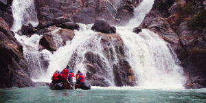 Passengers in Zodiac exp,oring a waterfall